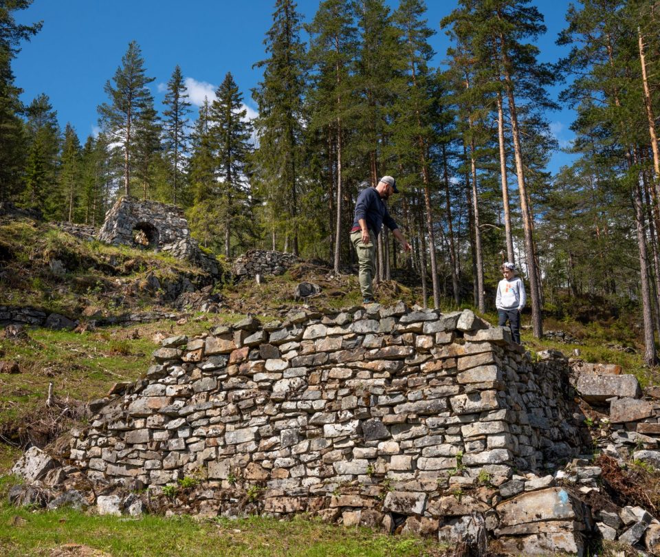 Mann på fottur ved gamle ruiner i Gruveåsen. Foto.