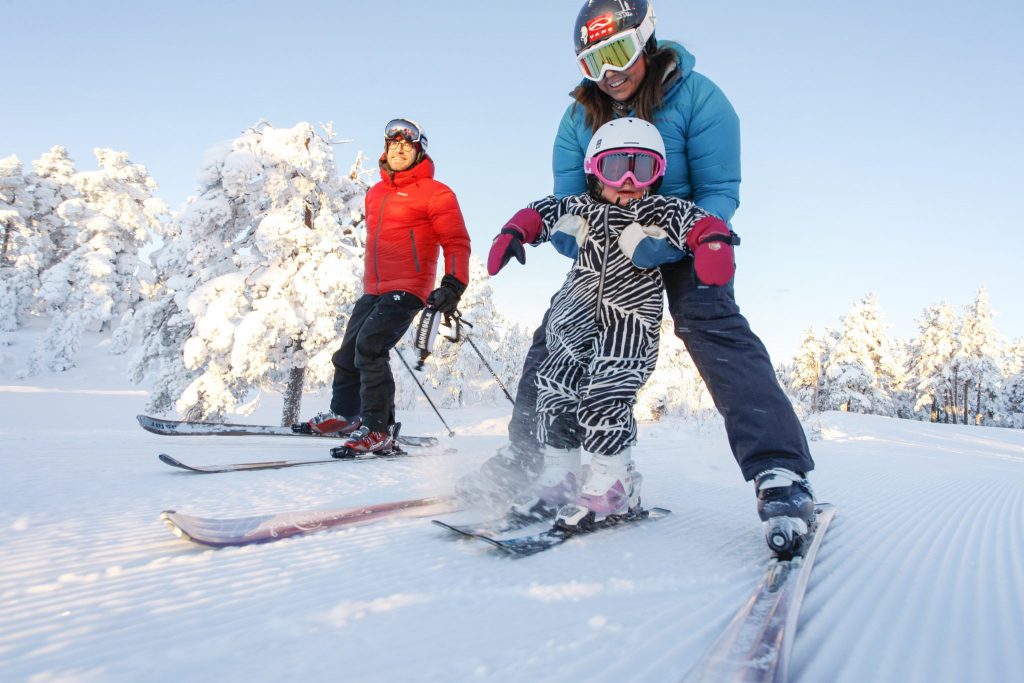 Familie står på slalom. Foto.